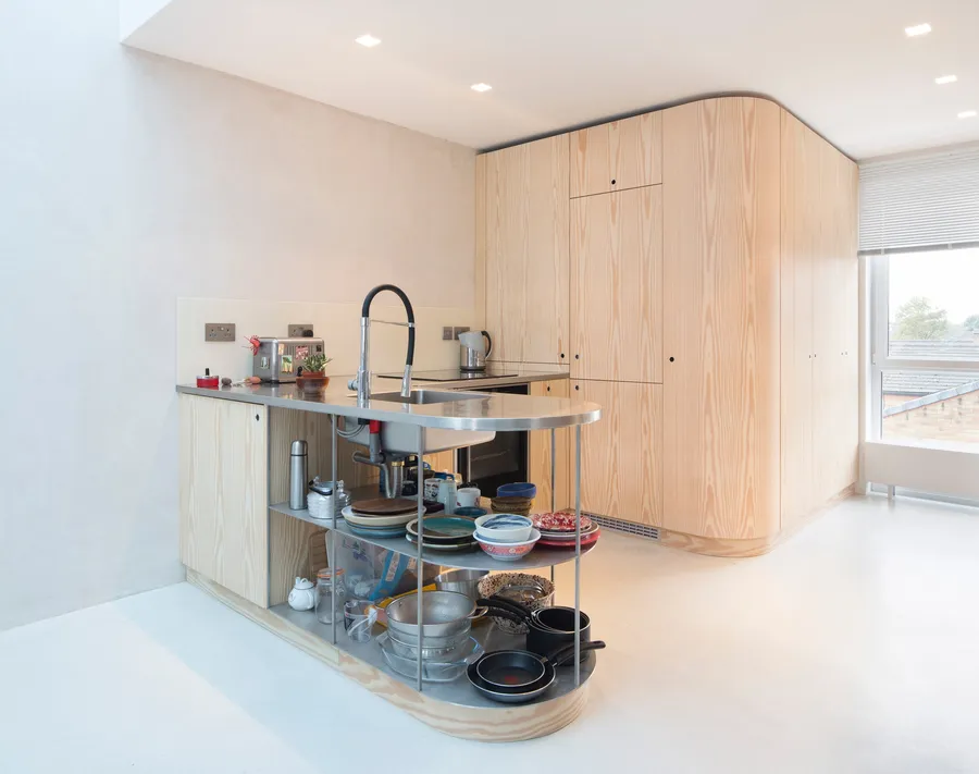 Curved Douglas Fir veneer kitchen​ with stainless steel counter-frame and worktops.