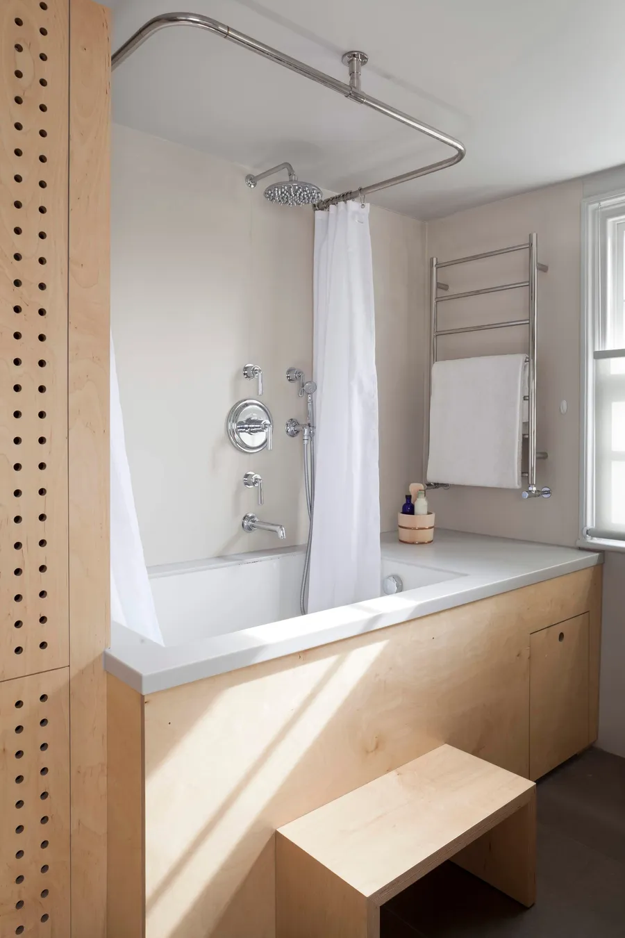 ​Modern bathroom, white Corian bath, birch plywood cabinetry.