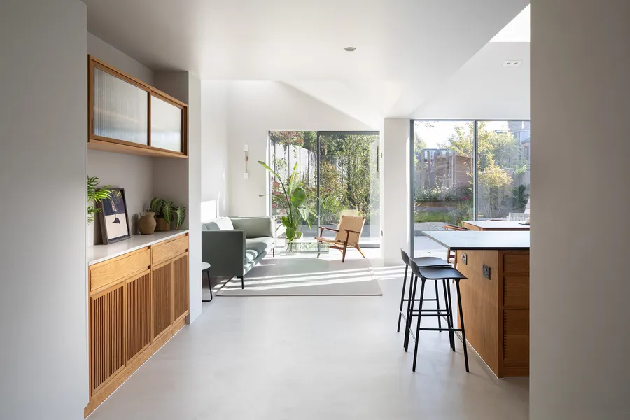 View past the oak sideboard and kitchen island to the living area and garden doors.