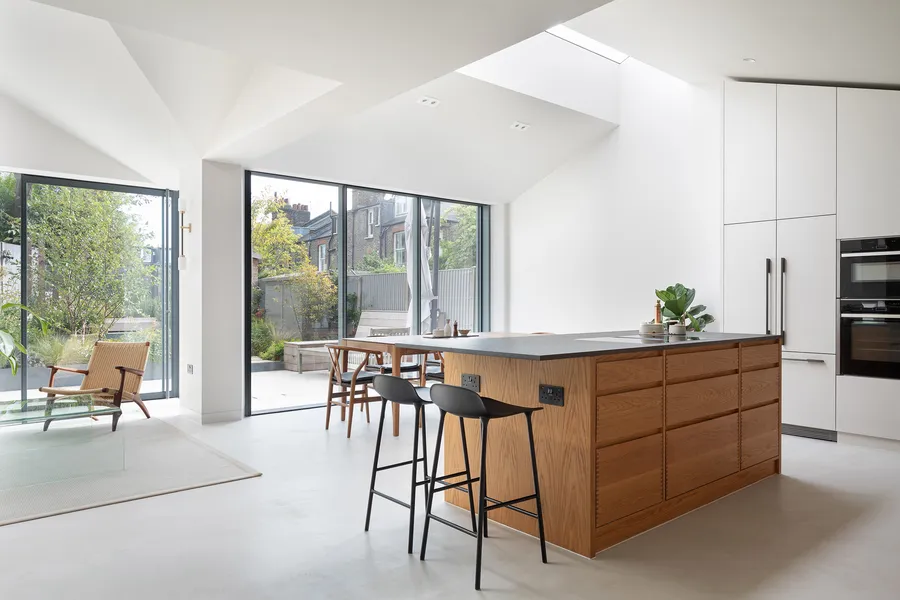Garden view into the rear extension, with the dining table and oak kitchen through open doors.