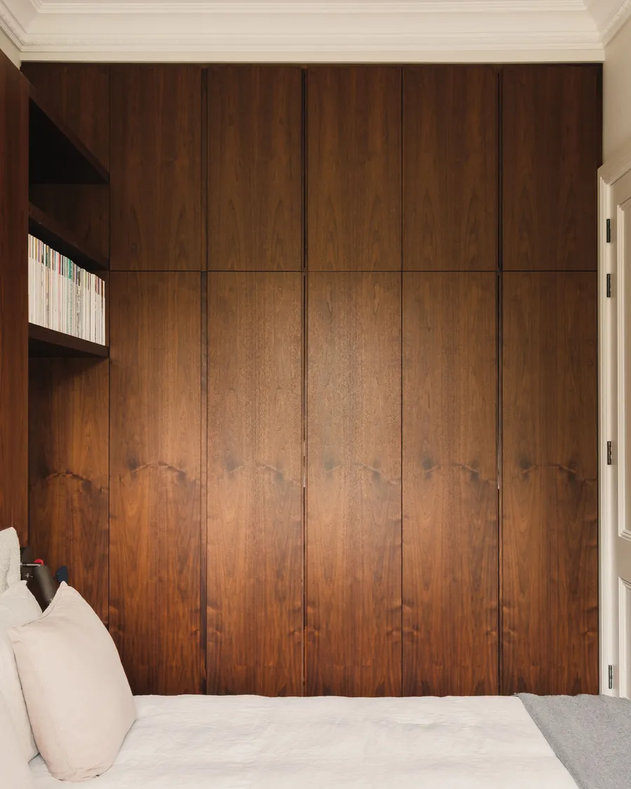 Custom veneered walnut doors with finger-pull handle detailing.