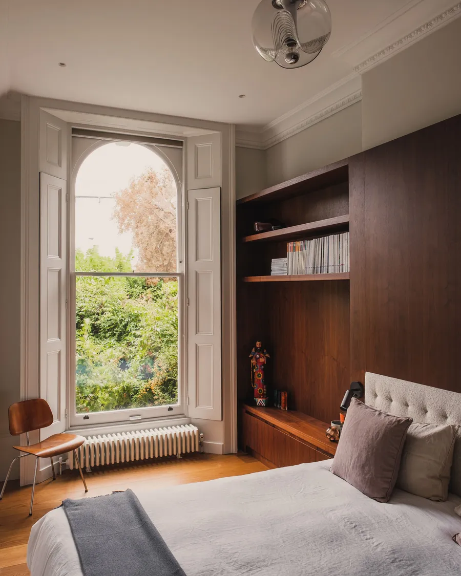 Walnut veneered panelling, window and bed.