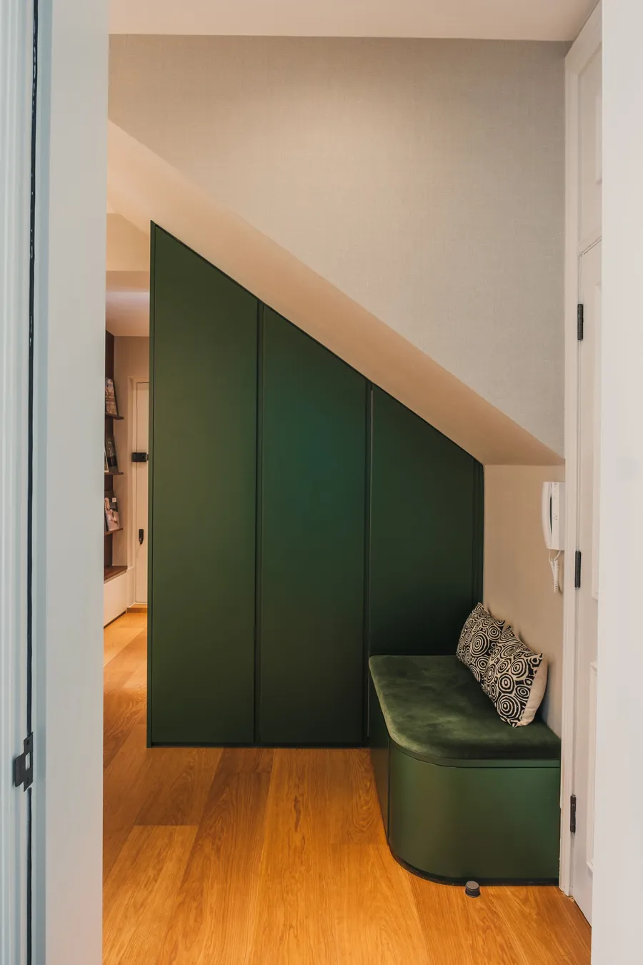 Green angled storage unit and upholstered bench seating.