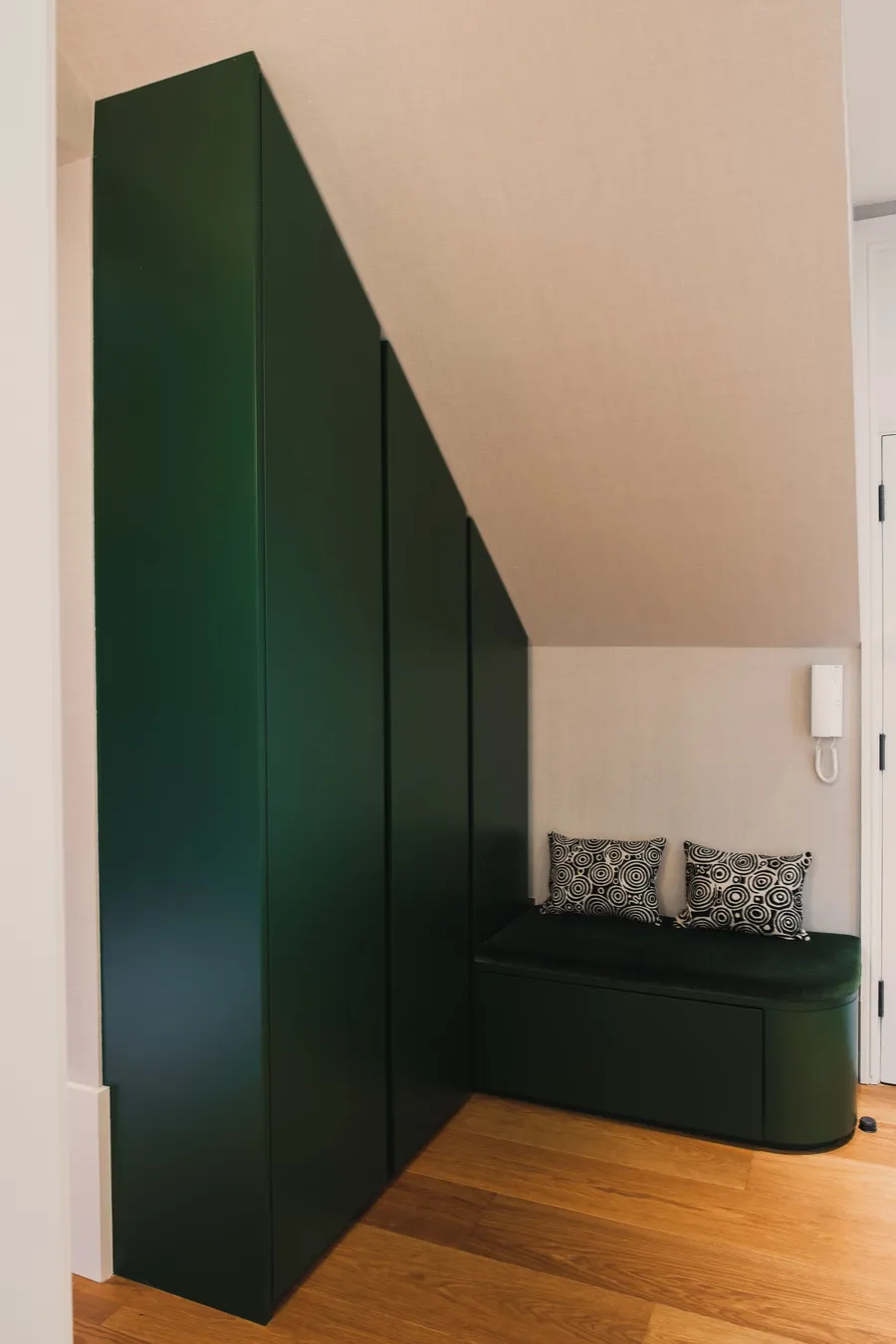 Green angled storage unit and upholstered bench seating.