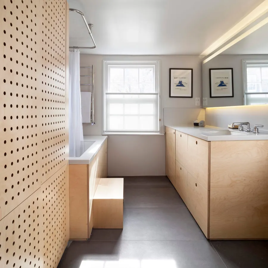 Bathroom with perforated birch plywood panelling, plywood bath surround, step and vanity.