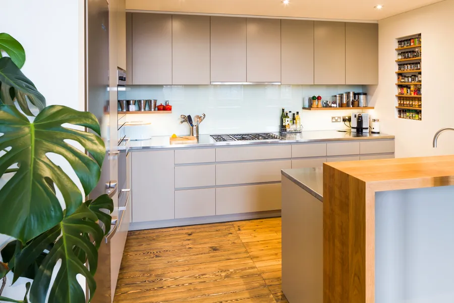 Modern kitchen with a mix of stainless steel and oak worktops, laminated plywood fronts and bespoke oak spice and plate racks.