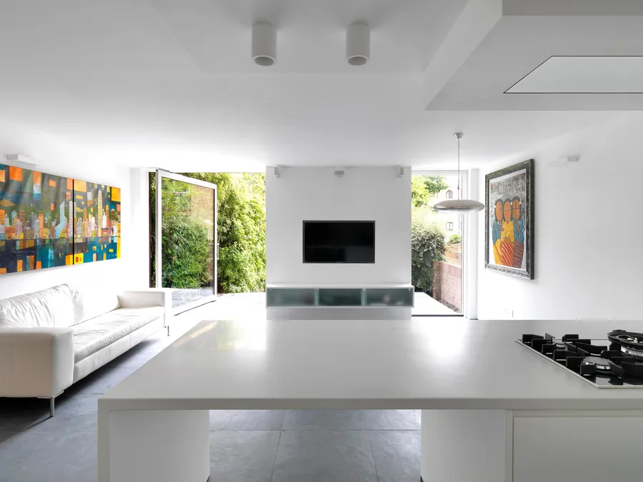 Modern kitchen with views through the open windows towards the garden.