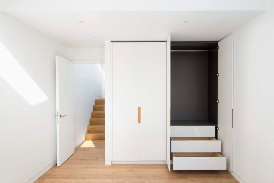 Wardrobe with PU lacquered fronts, oak inlay handles and dark grey melamine interior..