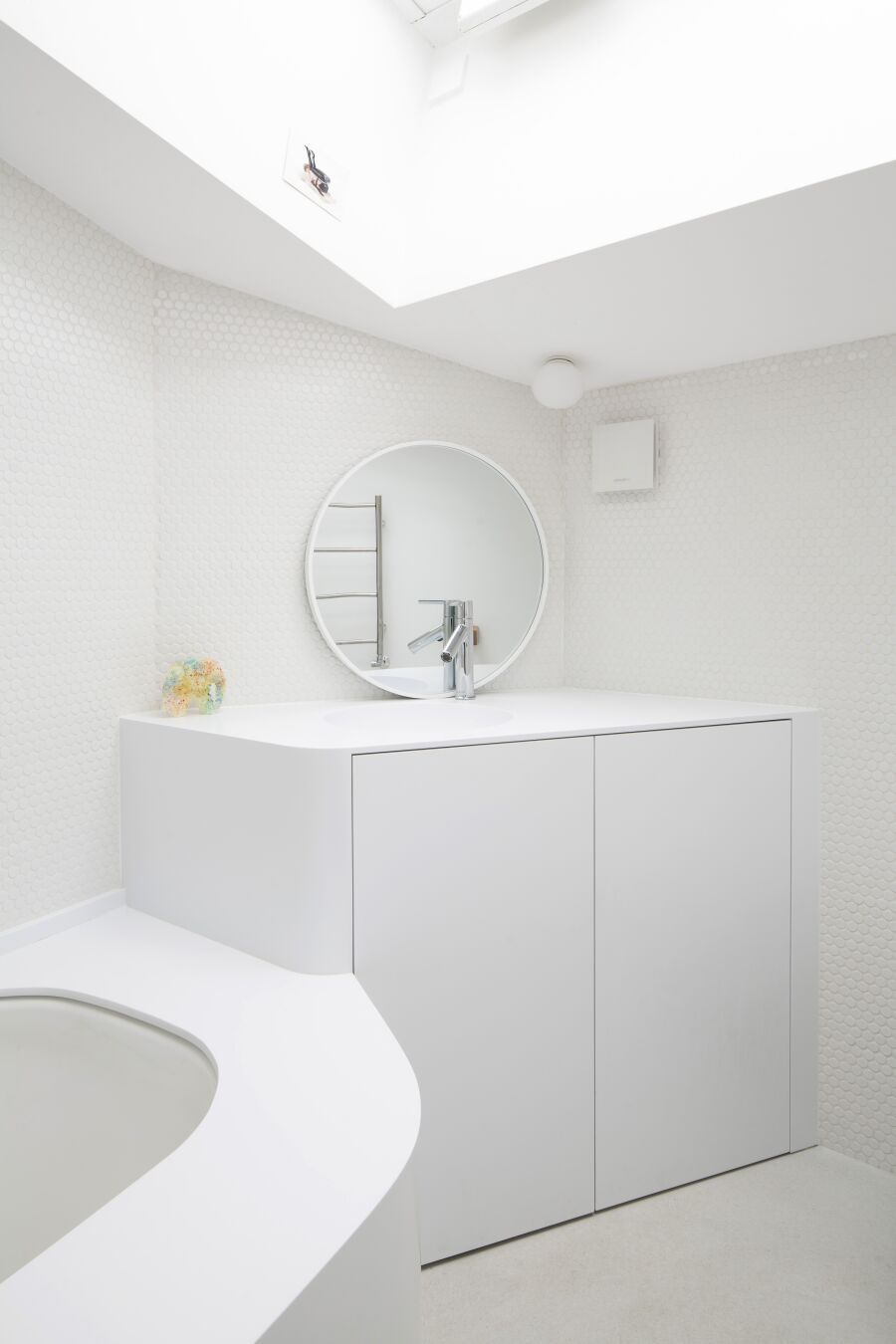 White curved Corian vanity unit and bath surround.