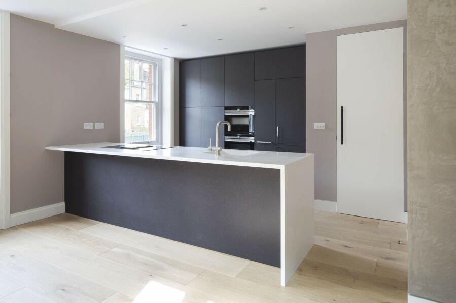 Modern kitchen with Corian worktop and black valchromat fronts..