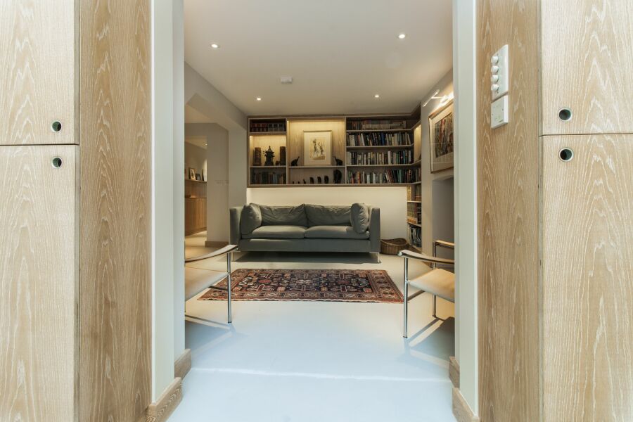 Limed oak veneered plywood floating library, alcoves and hallway shelving with LED lighting..