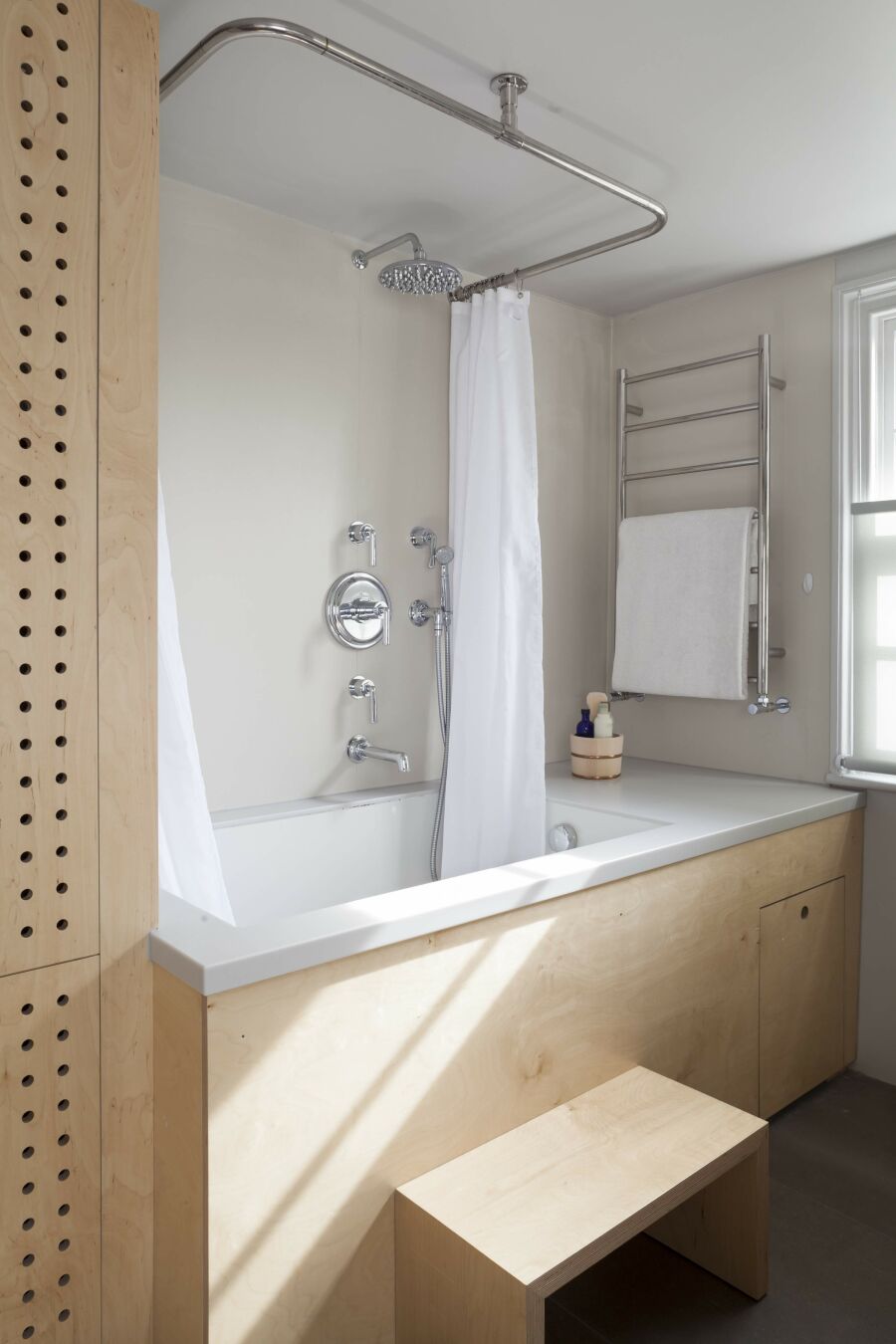 ​Modern bathroom, white Corian bath, birch plywood cabinetry..