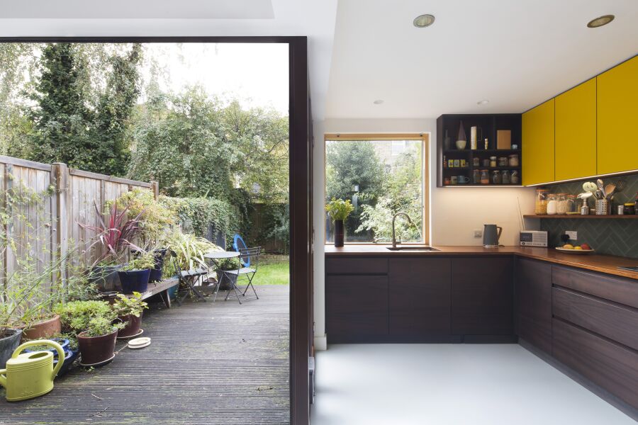 Kitchen with yellow laminate, stained Sapele on black Valchromat fronts and reclaimed solid Iroko worktops..