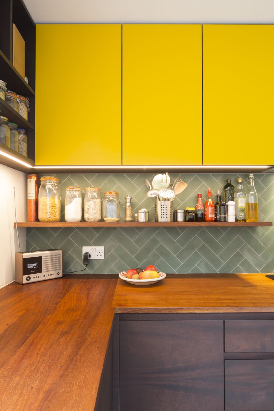 Kitchen with yellow laminate, stained Sapele on black Valchromat fronts and reclaimed solid Iroko worktops and shelving..