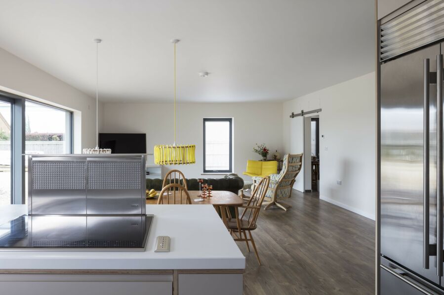 Open plan modern kitchen with appliances looking into the lounge dining room..