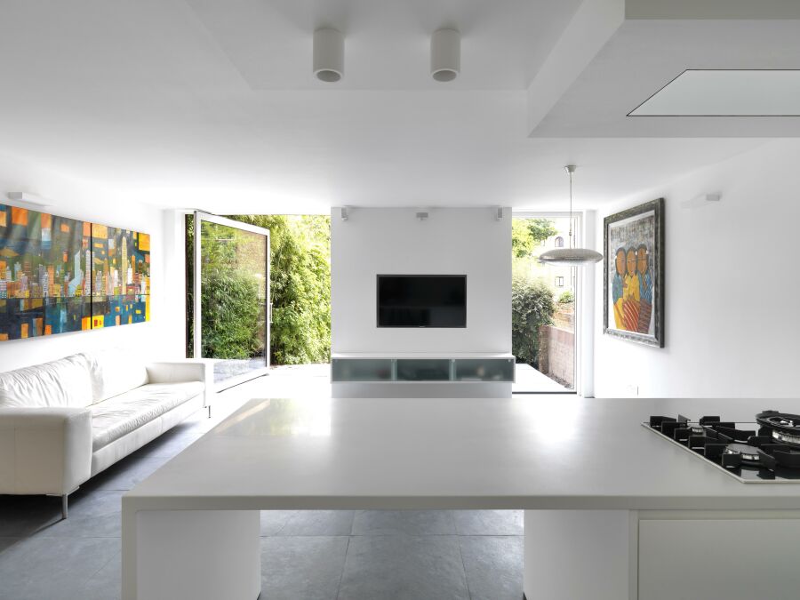 Modern kitchen with views through the open windows towards the garden..