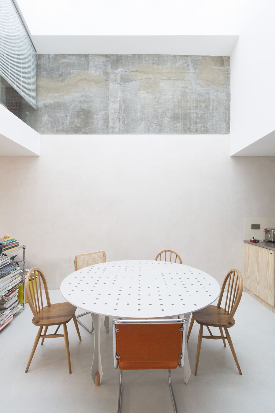 Perforated steel dining table in open plan dining area.